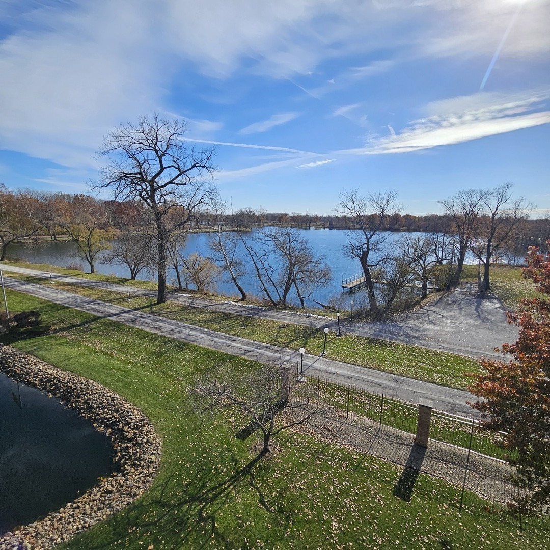 3620 186th Street, Unit 405 Lansing, IL 60438 - Photo 35 of 36 a view of a swimming pool with a bench and trees around