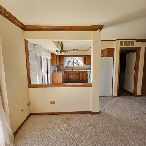 a kitchen with granite countertop a refrigerator and a stove top oven