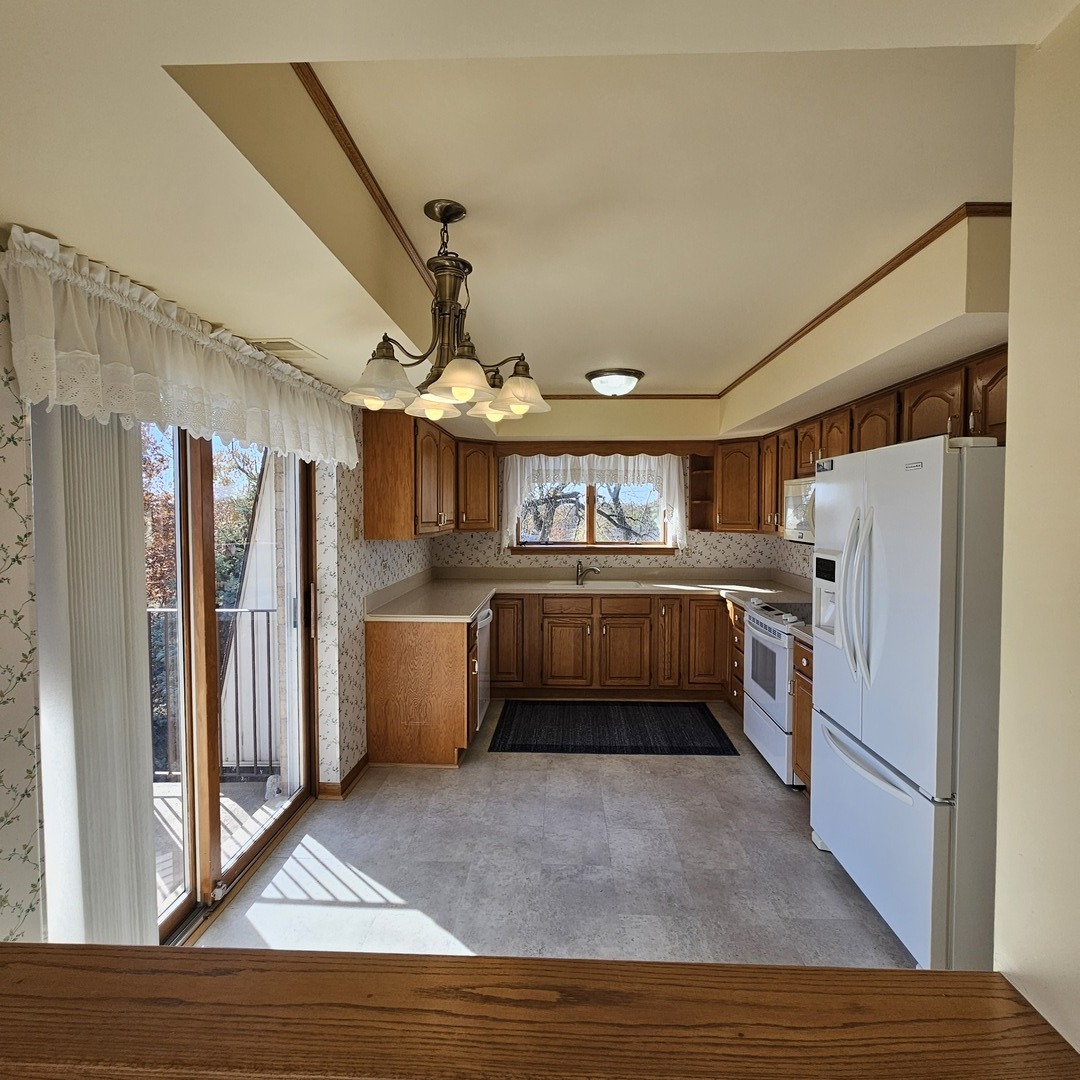 3620 186th Street, Unit 405 Lansing, IL 60438 - Photo 9 of 36 a kitchen with granite countertop a refrigerator and a stove top oven