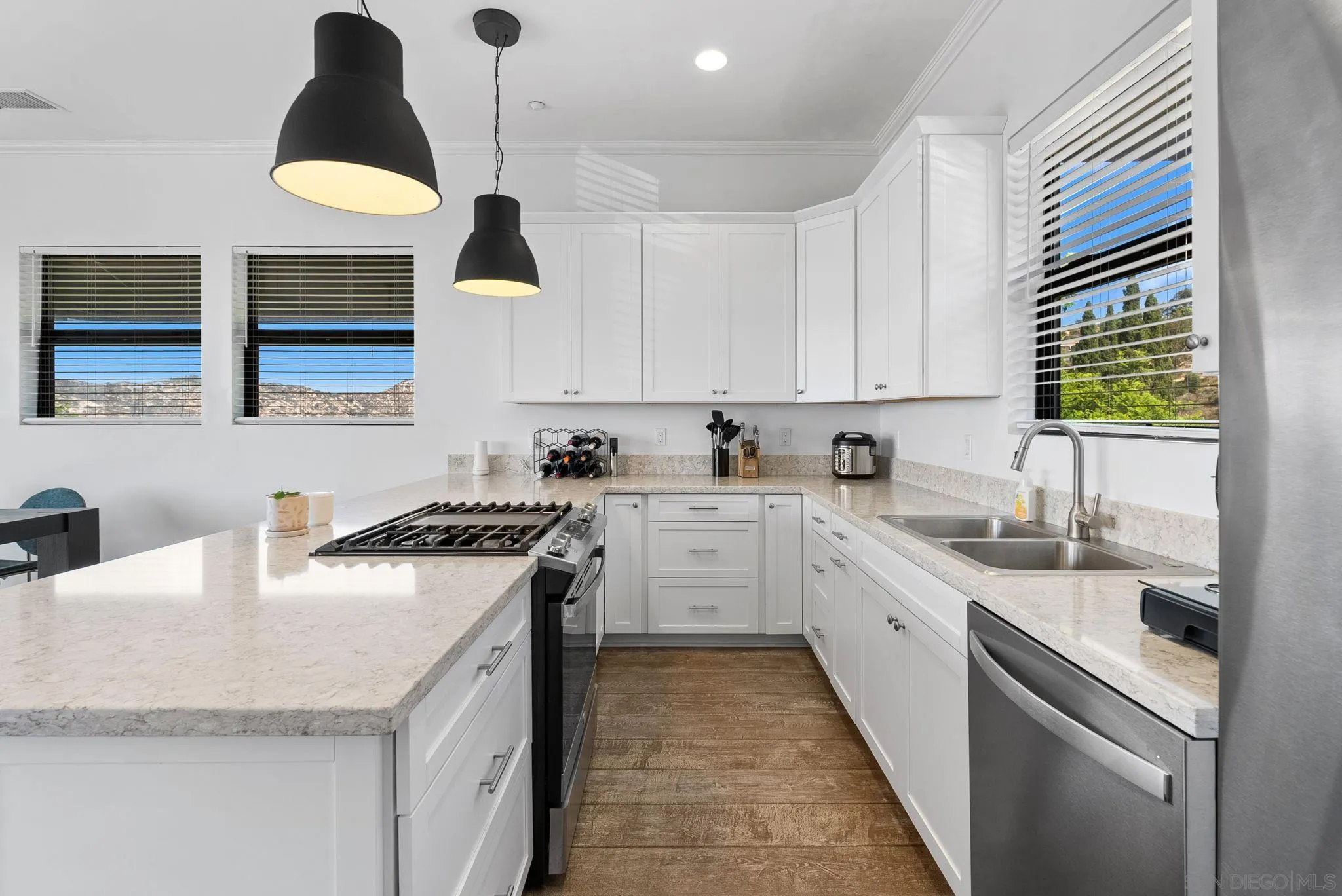 5521 Rainbow Heights Road Fallbrook, CA 92028 - Photo 9 of 36 a kitchen with a sink dishwasher a stove a microwave oven and a dining table with wooden floor