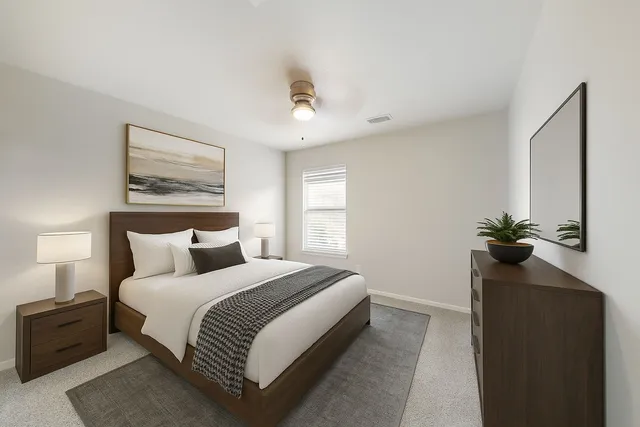 a spacious bedroom with a bed and a chandelier