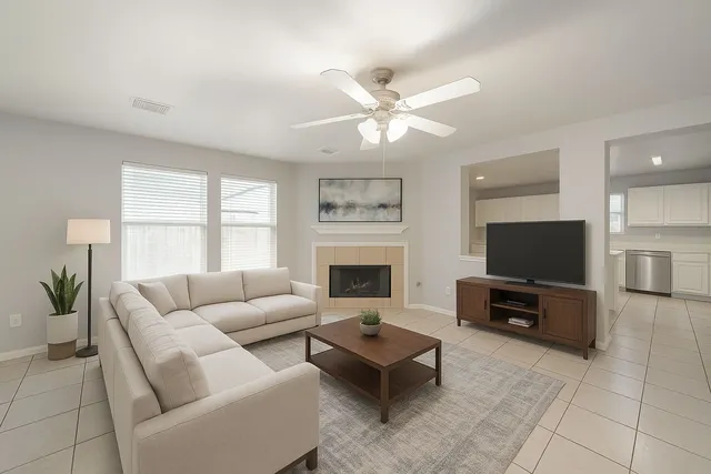 a living room with furniture a flat screen tv and a fireplace