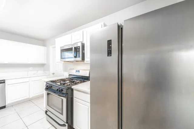 a kitchen with stainless steel appliances granite countertop a stove and a refrigerator