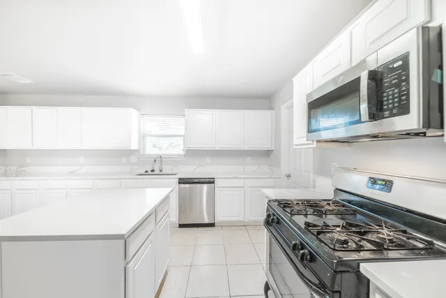 a kitchen with stainless steel appliances granite countertop a stove and a microwave