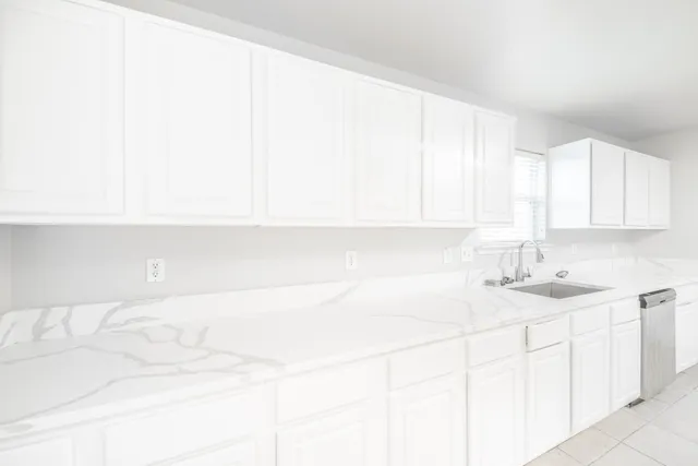 a kitchen with a sink cabinets and a window
