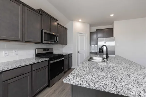 a kitchen with a sink a stove and cabinets