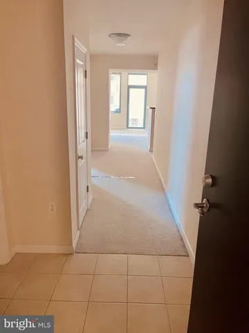 a view of an empty room with a window and chandelier fan