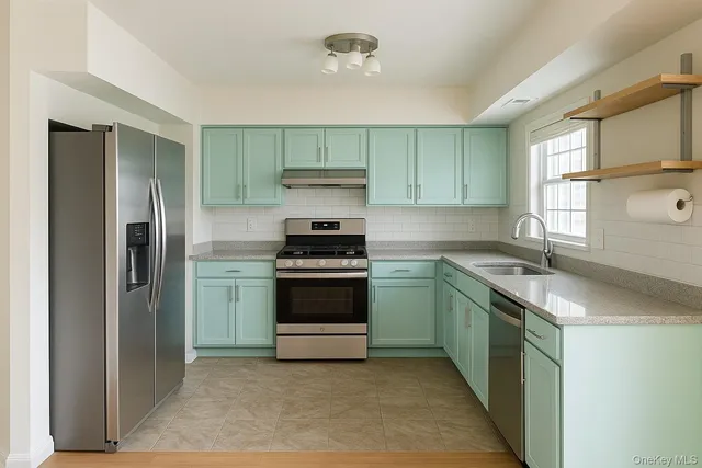 a kitchen with stainless steel appliances granite countertop a sink stove and refrigerator