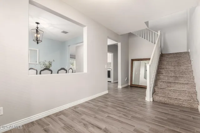 a view of a hallway with wooden floor and staircase