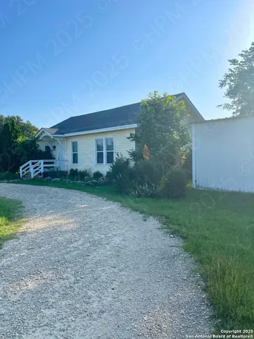 a view of a house with backyard and trees