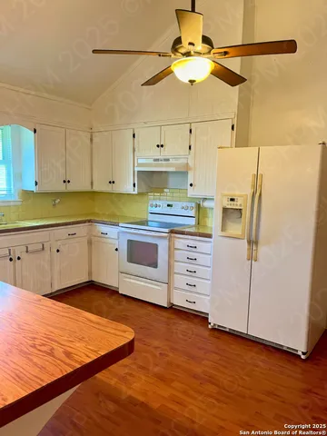 a kitchen with stainless steel appliances granite countertop a sink cabinets and wooden floor