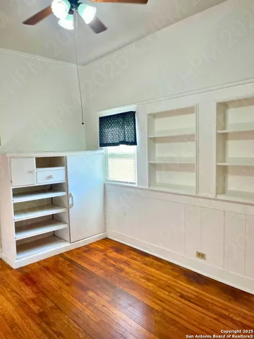 a view of empty room with a window and wooden floor
