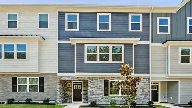 a front view of a house with a yard and outdoor seating
