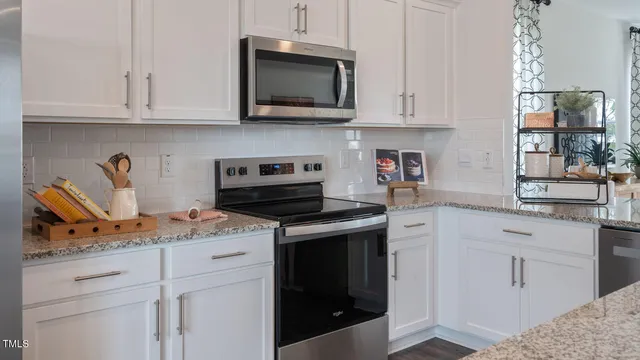 a kitchen with stainless steel appliances granite countertop a sink a stove and a refrigerator