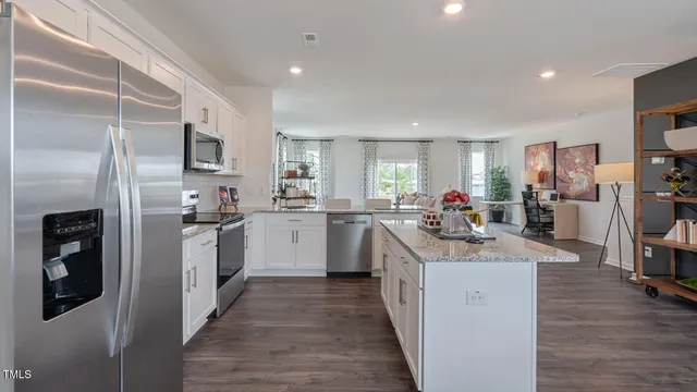 a kitchen with a dining table chairs and wooden floor