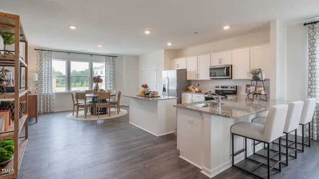 a kitchen with stainless steel appliances granite countertop white cabinets and a stove