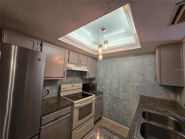 a kitchen with stainless steel appliances a stove a refrigerator and cabinets