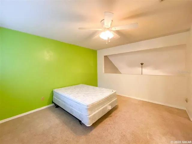 a bedroom with a bed and a ceiling fan