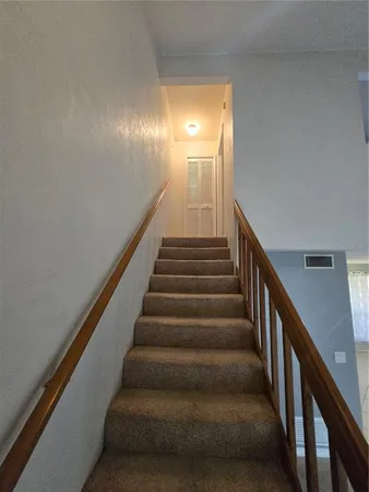 a view of staircase with lots of frames on wall