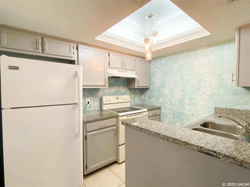 5855 Southwest 8th Place Gainesville, FL 32607 - Photo 4 of 19 a white refrigerator freezer sitting inside of a kitchen