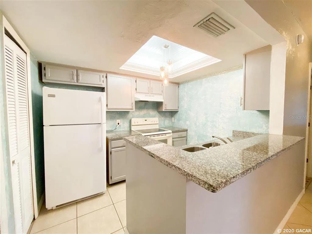 5855 Southwest 8th Place Gainesville, FL 32607 - Photo 6 of 19 a kitchen with a refrigerator a sink and a refrigerator