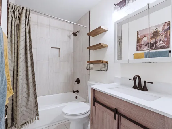 a bathroom with a sink a toilet a shower curtain and a bath tub