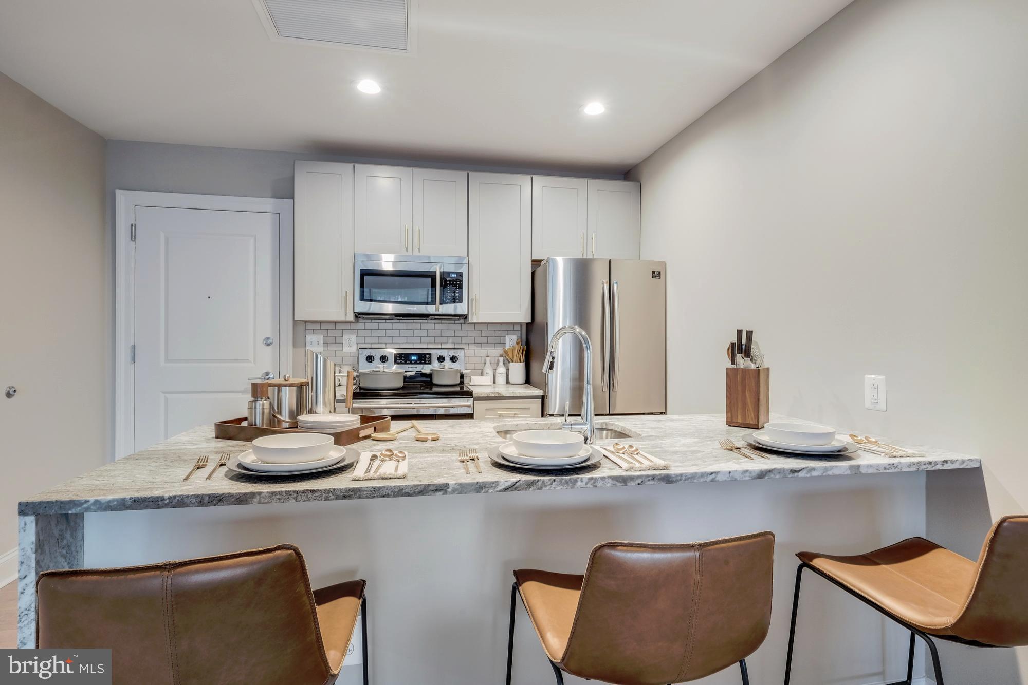 30 North 23rd Street, Unit 1808 Philadelphia, PA 19103 - Photo 4 of 42 a kitchen with stainless steel appliances granite countertop a sink refrigerator and cabinets