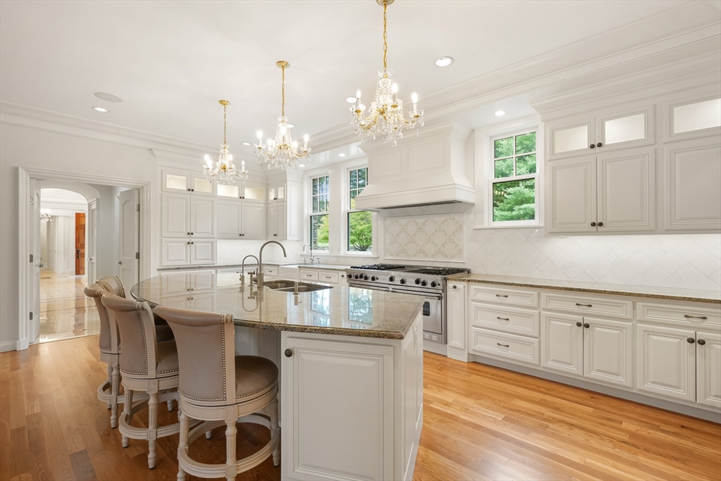 10 Wilson's Way Dover, MA 02030 - Photo 13 of 42 a large white kitchen with granite countertop a stove a sink a dining table and chairs with wooden floor