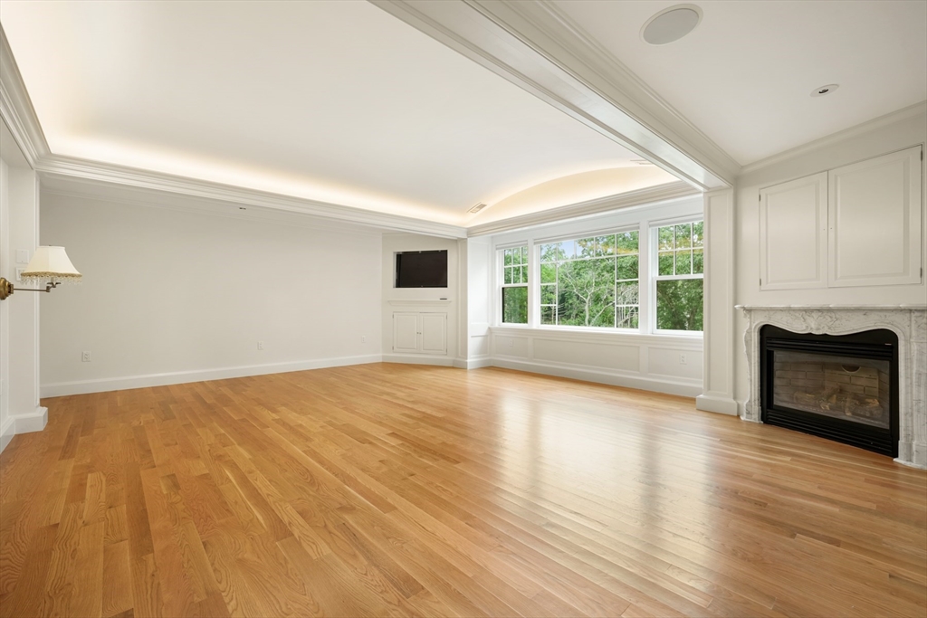 10 Wilson's Way Dover, MA 02030 - Photo 22 of 42 a view of empty room with wooden floor and fireplace