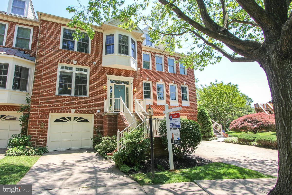 a front view of a house with a yard and trees