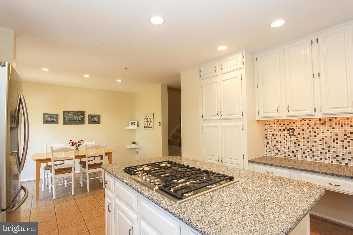 12666 Granite Ridge Drive North Potomac, MD 20878 - Photo 16 of 30 a kitchen with stainless steel appliances granite countertop a stove and a refrigerator