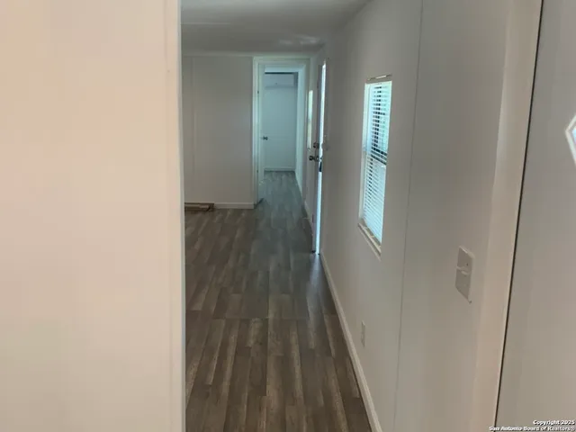a view of a hallway with wooden floor