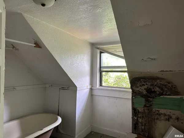 an empty room with windows and ceiling fan