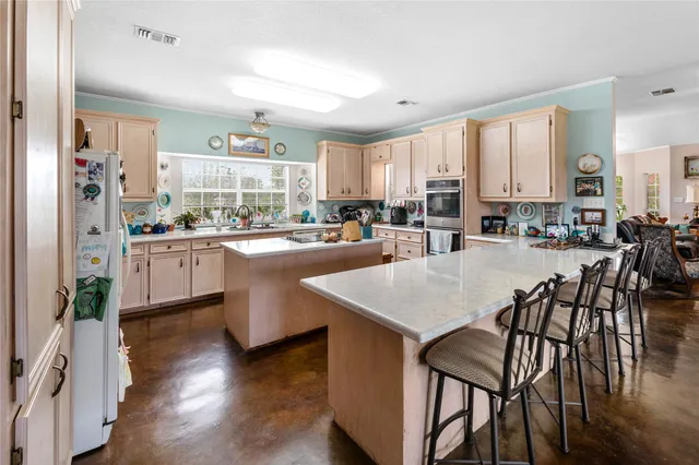 a kitchen with a table chairs stove and cabinets