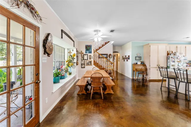 a dining room with wooden floor table and chairs