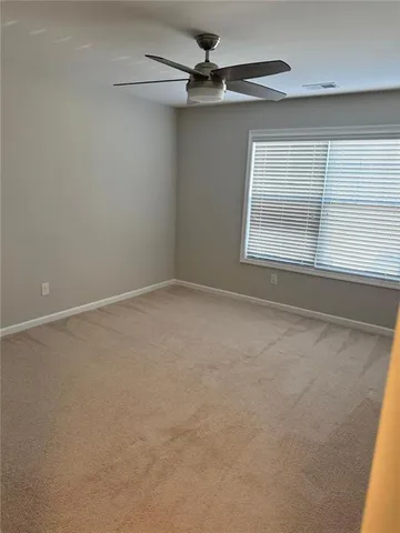 an empty room with a window and a ceiling fan