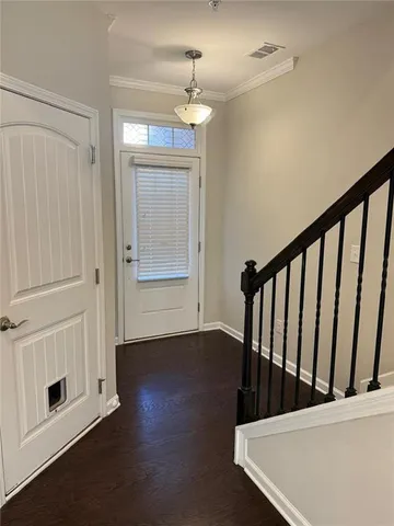 a view of a hallway with wooden floor and staircase