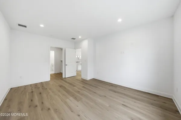 a view of empty room with wooden floor
