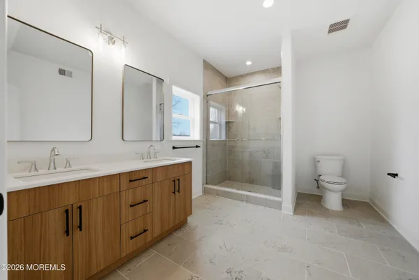 a bathroom with a double vanity sink toilet and shower