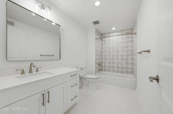 a bathroom with a double vanity sink toilet mirror and shower