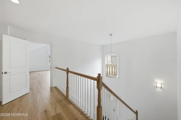 a view of a hallway with wooden floor and stairs