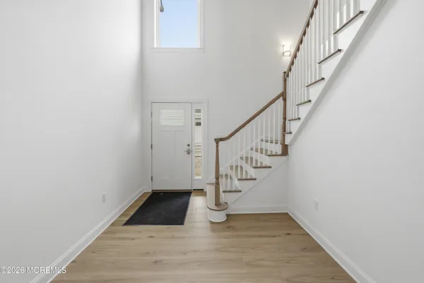 a view of entryway and hall with wooden floor