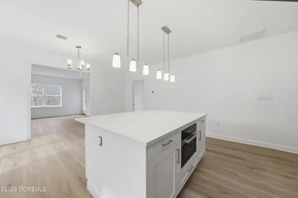 a kitchen that has a lot of cabinets and wooden floor