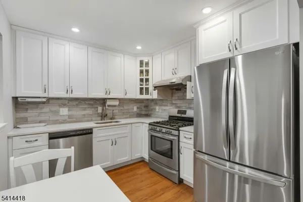 a kitchen with stainless steel appliances granite countertop a refrigerator sink and stove
