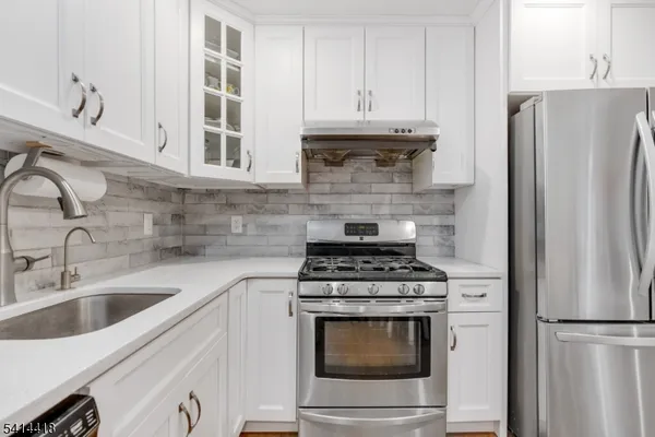 a kitchen with stainless steel appliances granite countertop a refrigerator stove and sink