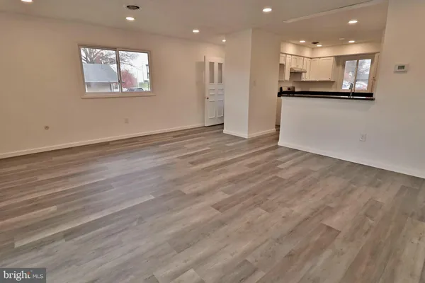 a view of a kitchen with kitchen island granite countertop wooden floors and white counter top