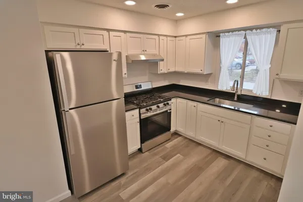 a kitchen with a refrigerator a sink and cabinets