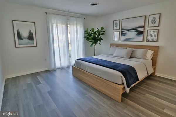 a spacious bedroom with a bed and a potted plant