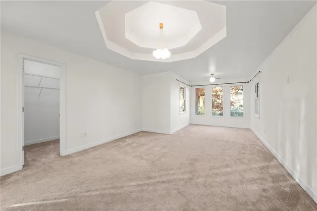 an empty room with window and chandelier