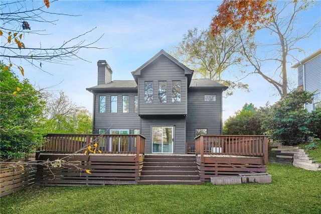 a view of a house with wooden deck and a yard